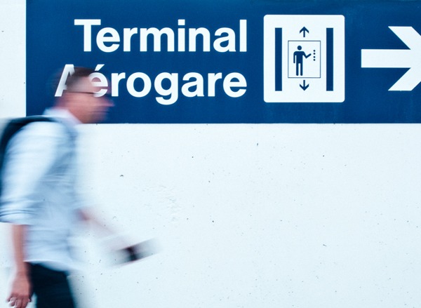 Un homme marche dans un aéroport avec un passeport en main