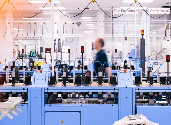 Man walking past passport manufacturing machine