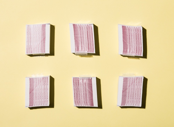 Stacks of excise stamps turned on their sides to show red ink detail