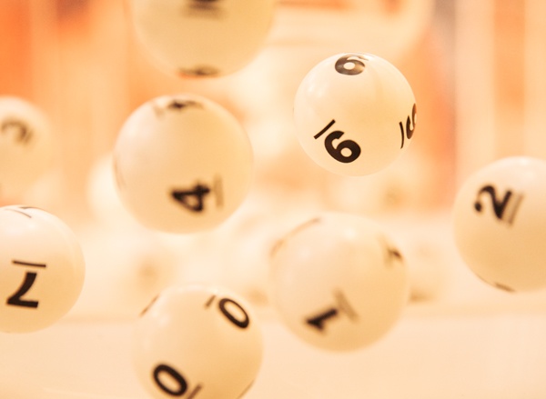 Des boules de loto blanches numérotées sont suspendues en mouvement.