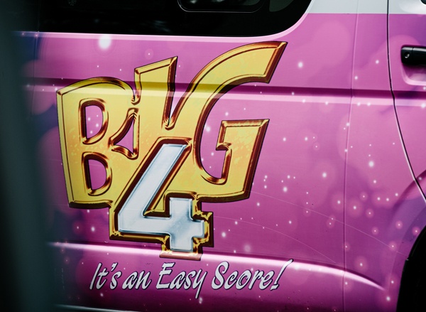 Portière d’un van de couleur rose vif portant l’inscription “Big 4 It’s an Easy Score!” : “Il est facile d’obtenir les 4 mêmes numéros !”